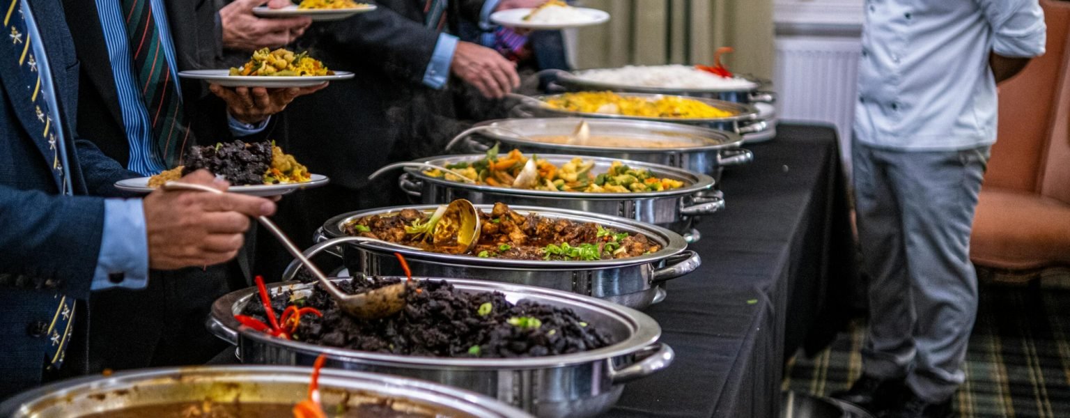 Business professionals in suits enjoy a diverse buffet lunch selection at a formal event.
